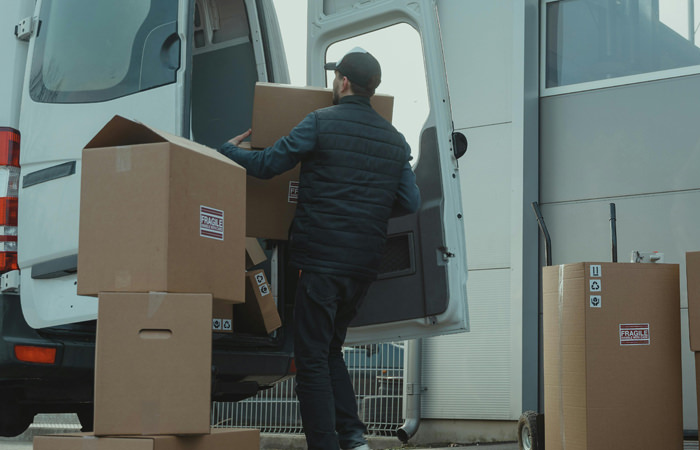 B2B Delivery Loading Process Worker Loading Boxes into White Transport Van for B2B Delivery – Efficient Delivery Services